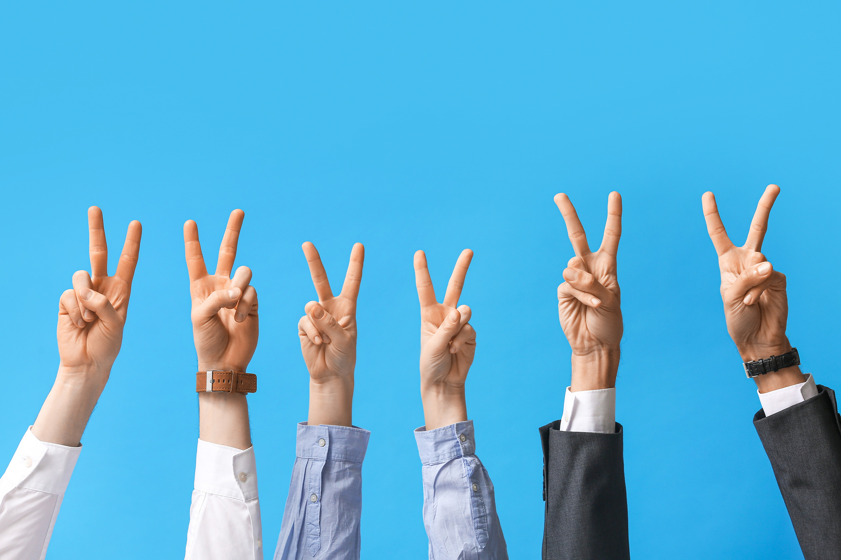 Business People Showing Victory Gesture on Blue Background